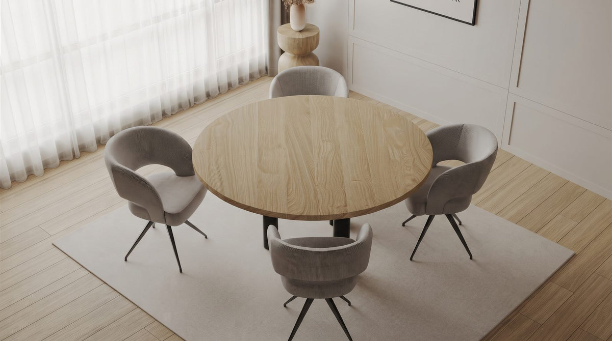 Ronde eiken eettafel met vier stoelen en loopruimte in een kleine eethoek