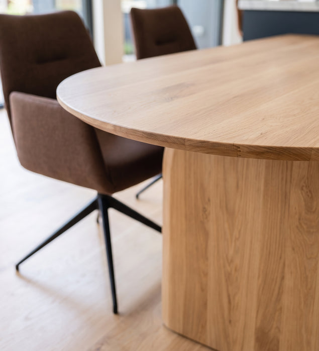 Detail van de afgeronde kop en de rand van de boogvormige eiken eettafel Natural