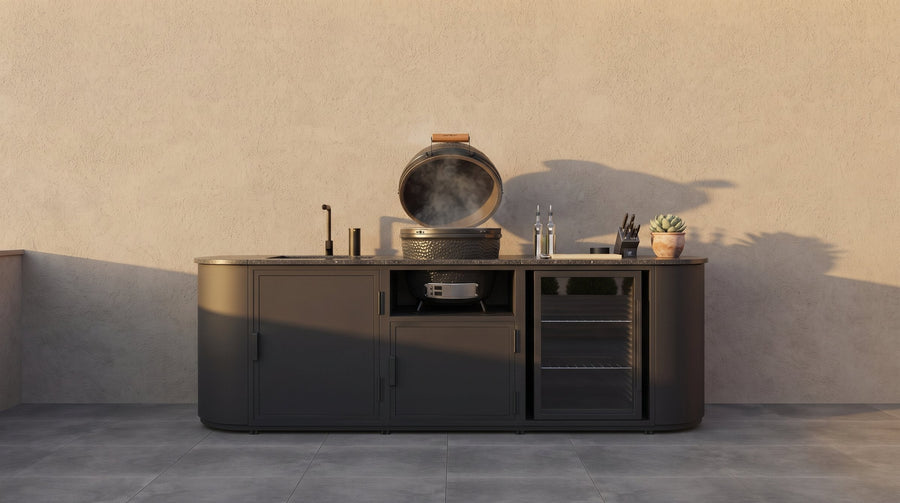 Buitenkeuken met ingebouwde kamado met open deksel, tegen een muur