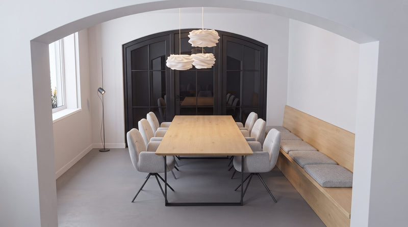 Smalle eiken eettafel met een bank tegen de muur in een smalle eetkamer