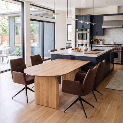 Boogvormige eiken eettafel met de rechte kant tegen het kookeiland