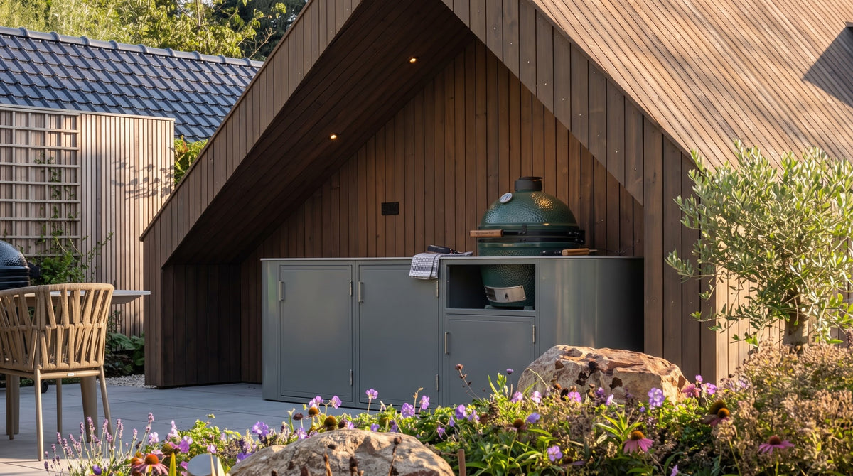 Grijze buitenkeuken met groene kamado-barbecue onder een houten overkapping