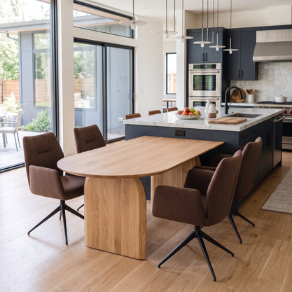 Boogvormige eettafel van massief eiken in Natural tegen een donker kookeiland