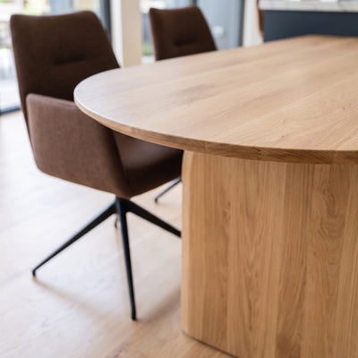Boogvormige eiken eettafel Natural met de rechte kant tegen het kookeiland